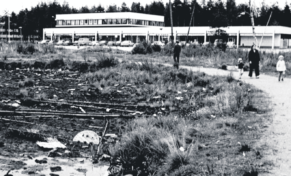Pohjoinen ostari 1960–70-lukujen taitteessa. Ostarilla oli muun muassa pankki, posti, apteekki, ravintoloita, kampaamoja, vaateliikkeitä, urheiluliike, kenkäkauppa ja elintarvikeliikkeitä. Viereisen Kangaslammen rannat olivat vielä tuolloin melko siivottomassa kunnossa. Kuva: Vuosaari-lehden arkisto