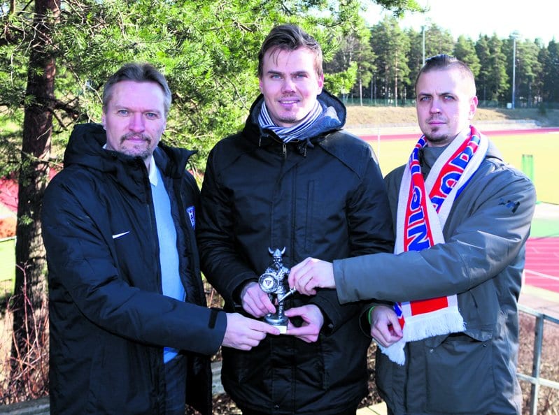 FC Viikinkien toiminnanjohtaja Marko Lahikainen (vasemmalla) ojensi Vuosaari-lehden edustajille Antti Honkaselle ja Aku Honkaselle Vuoden Viikinki -nimityksestä kertovan Viikinki-patsaan Heteniityntien urheilukentällä.