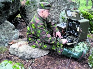 Kuvassa ansioitunut perinneradisti Leo Pajuvirta, OH1FJ, on vienyt vanhan VRFK-sotilasradioaseman maastoon Koivulan kallioille, Turussa. Kuva: Leo Pajuvirran kotialbumista