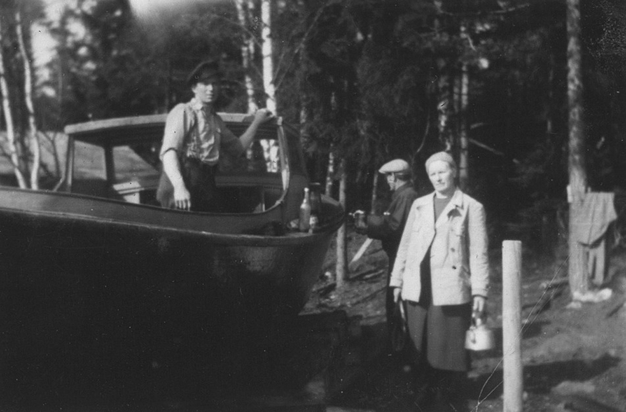 Ensio Mäkinen kunnostamassa venettään. Kuvassa myös vuosaarelainen kalastajapariskunta Axel ja Rosa (kahvipannu kädessään) Forström.