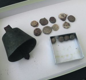 Kuvassa on Skatan tilan ympäristöstä metallinpaljastimella löytynyt vanha soittokello, sinettejä sekä musketin kuulia.