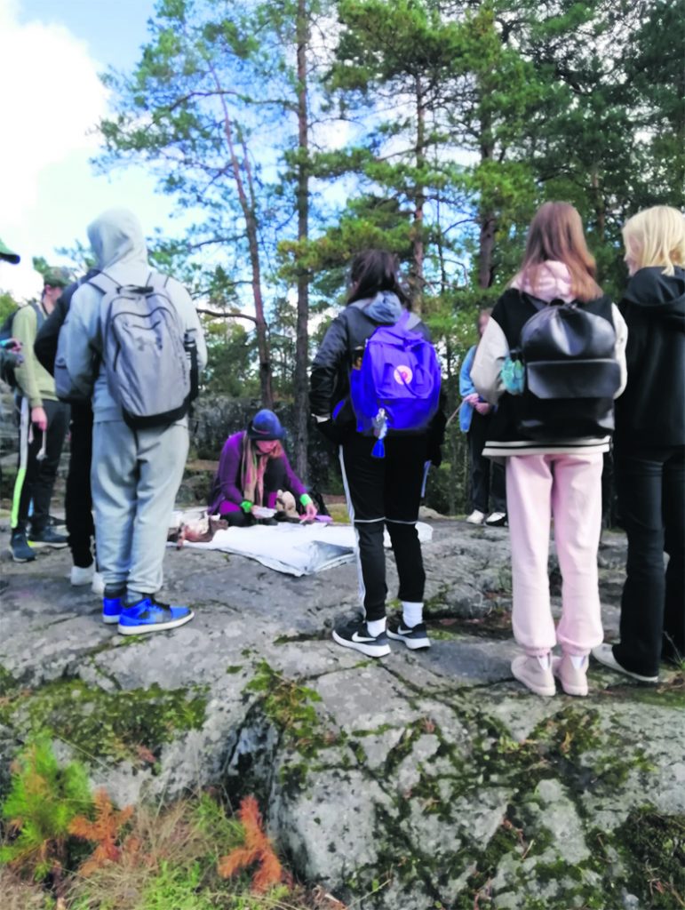 Milla Tuormaa oppilaiden keskellä Pohjavedenpuistossa.