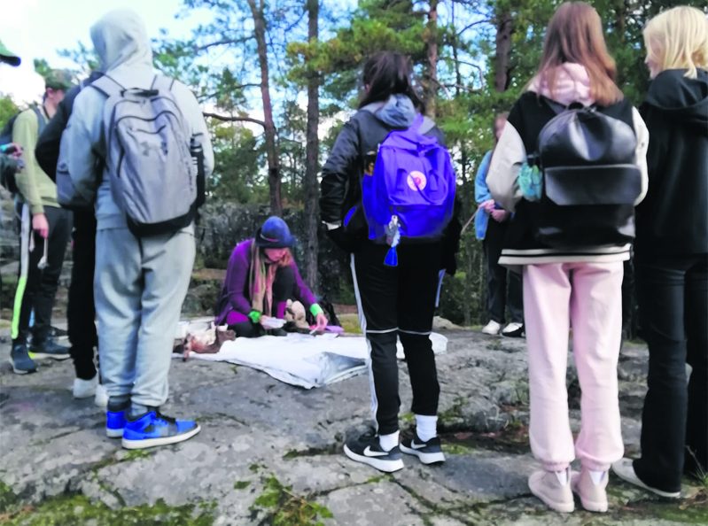 Milla Tuormaa oppilaiden keskellä Pohjavedenpuistossa.