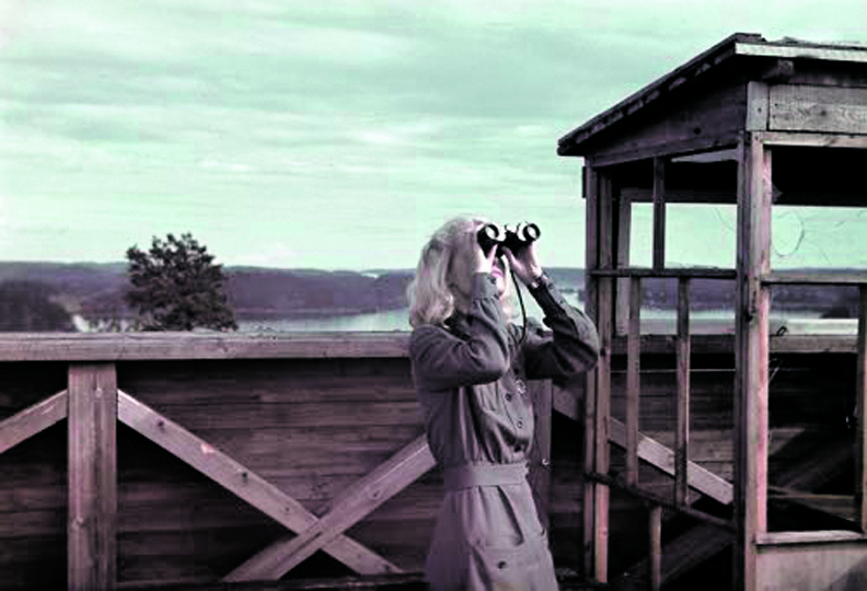 Erilaisia ilmavalvontatorneja sijaitsi ympäri Helsinkiä ja muuta maata. Kuvassa Lahdenpohjan ilmavalvontatorni ja ilmavalvontalot- ta Ellen Kiuru marraskuussa 1942. Kuva: SA-kuva