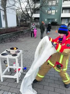 Nuoriso-osaston Lauri näytti, kuinka sammutuspeitettä käytetään.