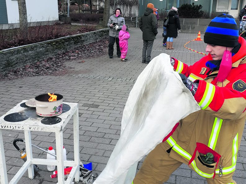Nuoriso-osaston Lauri näytti, kuinka sammutuspeitettä käytetään.