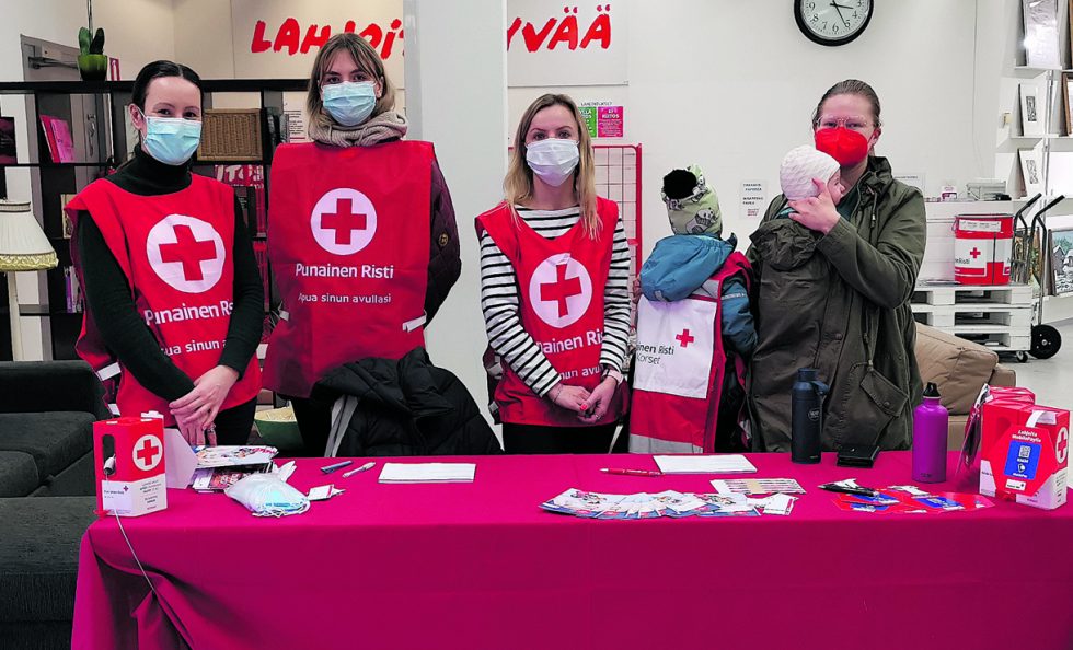 Puheenjohtaja Sanna (oik.) piipahti tervehtimään keräystiimiä Itäkeskuksessa. Punaisissa liiveissä Denisa (vas.), Judit ja Daria sekä välissä kaksi pikkuvapaaehtoista. Kuva: Eveliina Puustinen