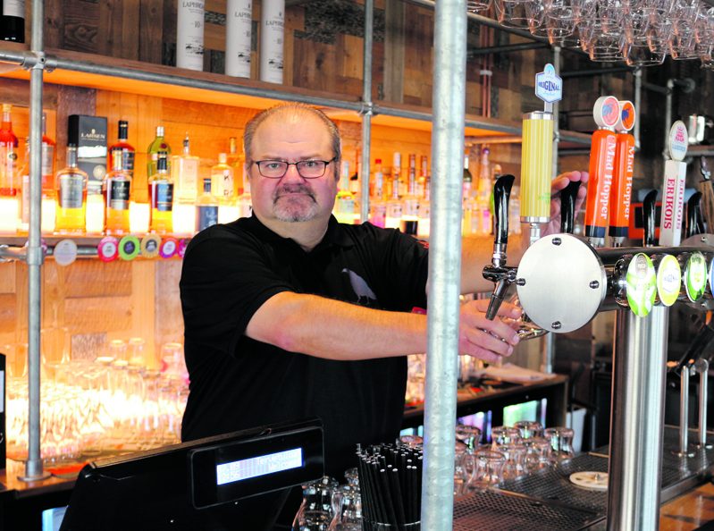 Ravintola The Blue Birdin ravintolapäällikkö Isto Puttonen baaritiskin takana. Ravintolan sisustus on rouhevan teollisuusmainen: baaritiskikin on tehty hauskasti rakennustelineistä.