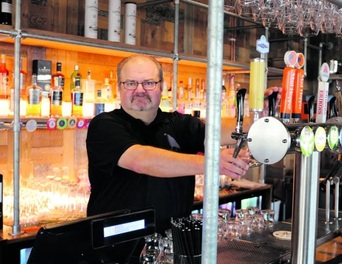 Ravintola The Blue Birdin ravintolapäällikkö Isto Puttonen baaritiskin takana. Ravintolan sisustus on rouhevan teollisuusmainen: baaritiskikin on tehty hauskasti rakennustelineistä.
