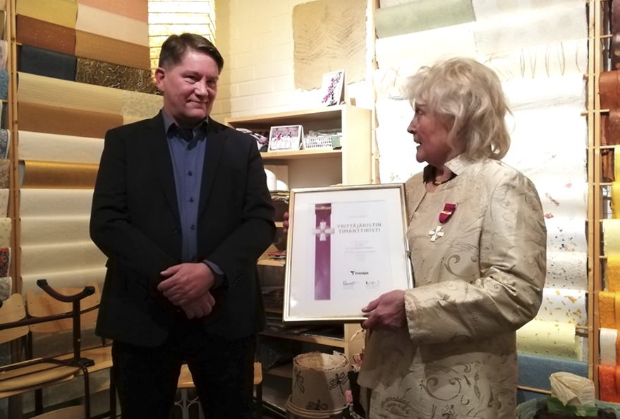 Itä-Helsingin Yrittäjien puheenjohtaja Pekka Pirkkala luovutti kunniakirjan ja timanttiristin Riitta Reini-Strömmerille.