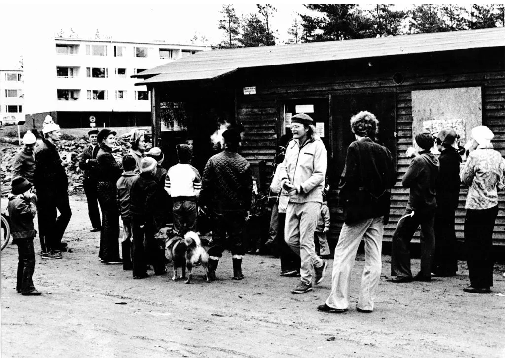 Liikuntatapahtuma Heteniityntien urheilukentän luona vuonna 1966. Kuvan parakki oli Heteniityntien urheilukentän nykyisten pukukoppien paikalla. Paikalla muun muassa Vuosaaren Urheilukalastajat valoivat lasikuituveneitä ja Vuosaaren eri rakennustyömailta oli paikalle tuotu varastoitavaksi valtavat määrät tiiliä. Kuvassa vasemmalla ainakin pipopäinen Vuosaaren yhteiskoulun silloinen rehtori Pertti Kunnamo.