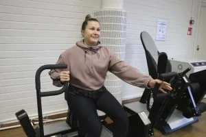 Urheiluhallien liikuntavastaava Karoliina Summanen esittelee Kuntosali 2:n uutta HUR-laitetta.