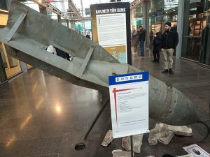 Kuvassa vasemmalla näyttelyssä esillä oleva neuvostoliittolainen 500 kg:n pommi, jollaisilla Helsinkiäkin pommitettiin.