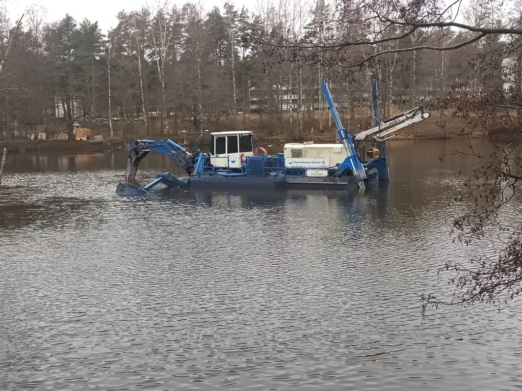 Kangaslammen pohjaa ruopataan imuruoppaajalla. Putkia pitkin liete menee geotuubisäkkeihin.                              Kuva: Vuosaari-lehti