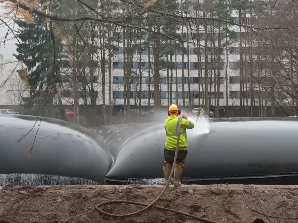 Vesi valuu takaisin lampeen geotuubisäkkien pienistä rei´istä, ja liete jää tuubin sisälle. Ravinteikas liete voidaan myöhemmin hyödyntää esimerkiksi viherrakentamisessa.            Kuva: Vuosaari-lehti