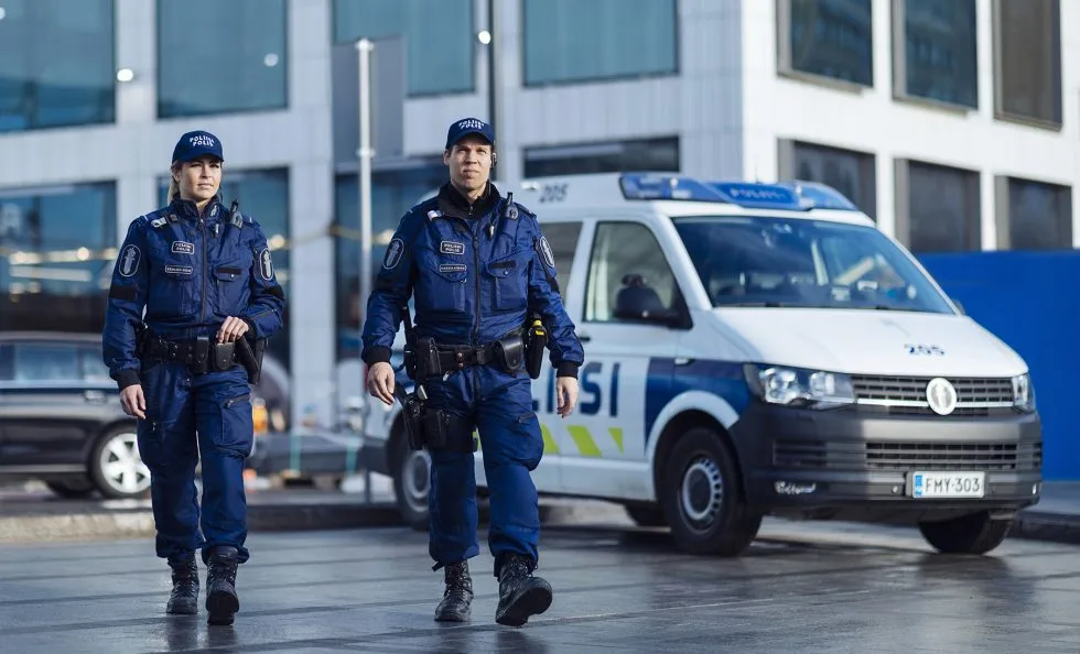 Kaksi poliisia ja poliisiauto.