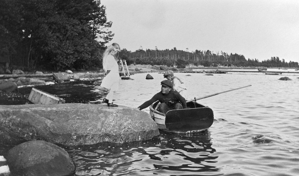 Kuva Kallahdenniemestä (Kallvik). Dorrit Greuling kivellä, Frank Greuling ja soutajapoika veneessä. Taustalla laivalaituri.                                                  Kuva: Greta Elmgren 1912, Helsingin kaupunginmuseo