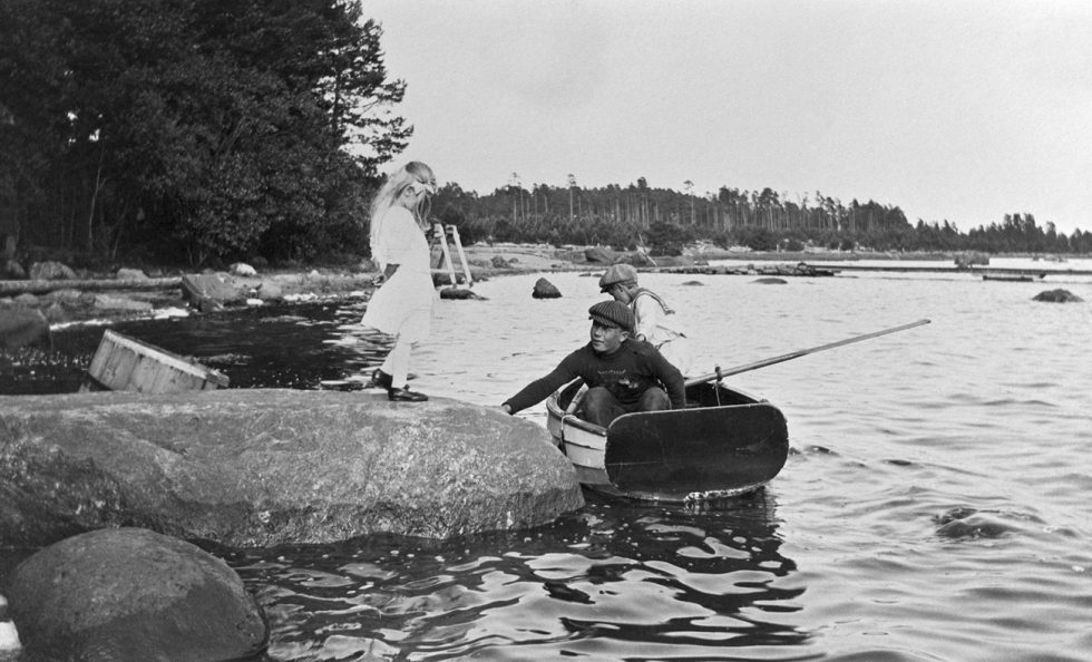 Kuva Kallahdenniemestä (Kallvik). Dorrit Greuling kivellä, Frank Greuling ja soutajapoika veneessä. Taustalla laivalaituri. Kuva: Greta Elmgren 1912, Helsingin kaupunginmuseo