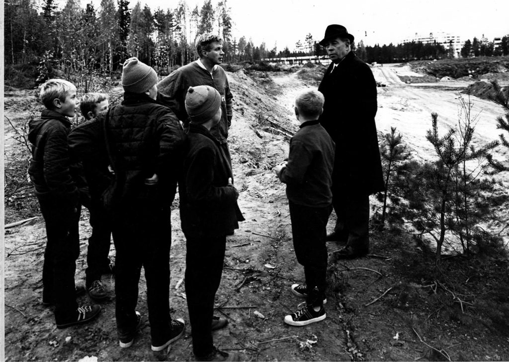 ”Keisari” Martti Ilveskorpi ja futistähti Kaj Pahlman tarkastelevat poikien kanssa Hettarin urheilukentän valmistumista vuonna 1965.