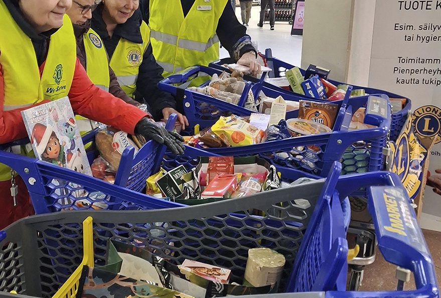 Soihtujen naiset tutkivat tyytyväisinä ostoskärryihin kertyneitä tavaroita. Lahjoittajien antama apu lähtee yksinhuoltajaperheille.