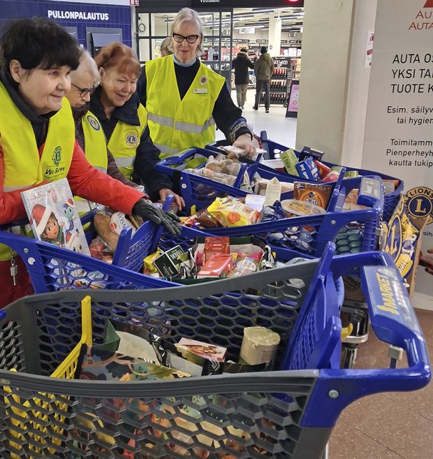 Soihtujen naiset tutkivat tyytyväisinä ostoskärryihin kertyneitä tavaroita. Lahjoittajien antama apu lähtee yksinhuoltajaperheille.