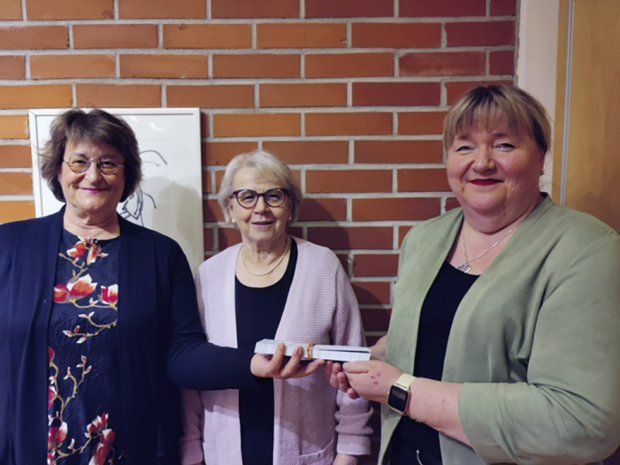 Kuvassa Vuosaaren seurakunnan diakoniatyön johtava viranhaltija Tuula Mäkinen (kuvassa oikealla) vastaanotti ruokalahjakortit. Soihduista klubipresidentti Sari Sepponen (vasemmalla) ja sihteeri Tellervo Ukkonen.
