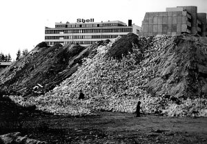 Vuosaarentie 3:n kohdalla sijaitsi rakennusjätteen kaatopaikka vielä 1970-luvulla. Takana Ulappasaarentie 4:ssä sijaitsi Shellin pääkonttori ja oikealla Ulappasaarentie 1:n terassitalo. Terassitalot valmistuivat vuosina 1969–71. Vuokeskus eli Raken ostari ja kirjasto pilkottavat kuvan vasemmassa reunassa. Kuva: Vuosaari-lehden arkisto