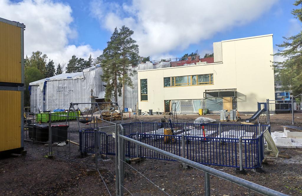 Oikealla kuvassa näkyy koulun kaksikerroksinen laajennusosa, vanha koulurakennus näkyy huputettuna.