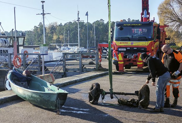 Laiturille merestä nostettu vene ja autonakseli.