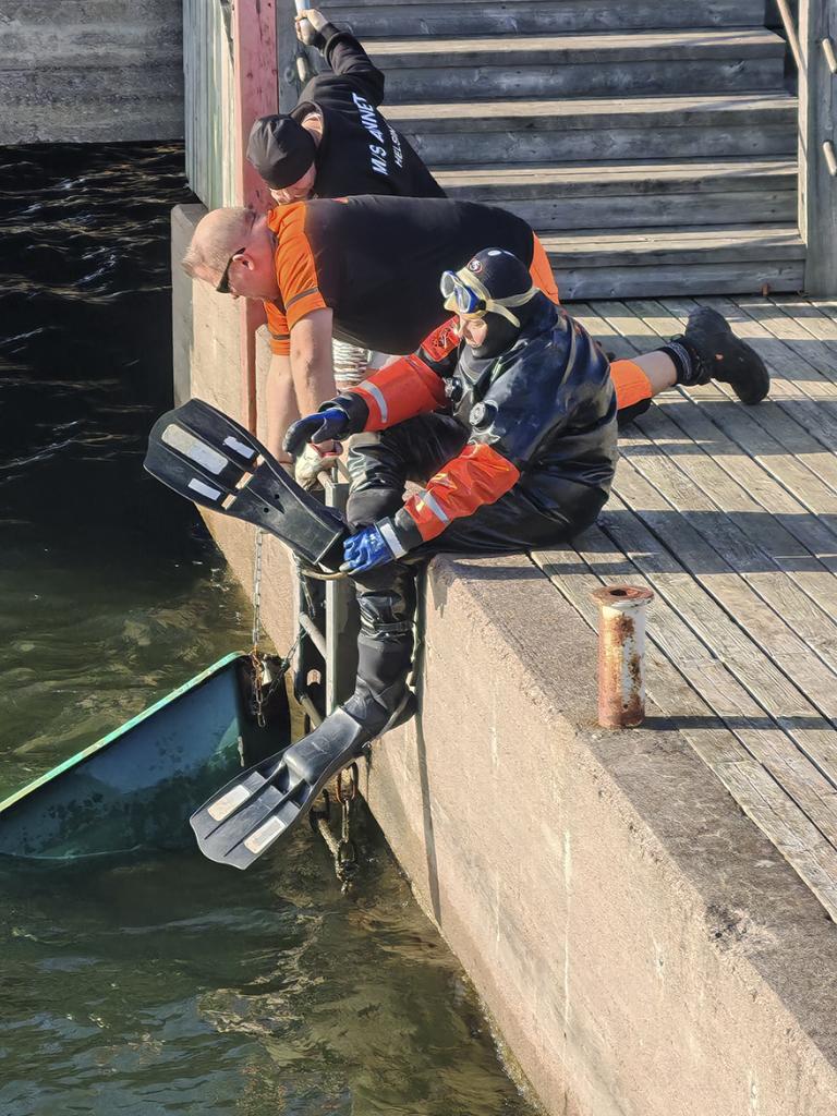 Sukeltaja Jenni Sundell (etualalla) Pääkaupunkiseudun Etsintä ry:stä valmistautui sukellukseen.
